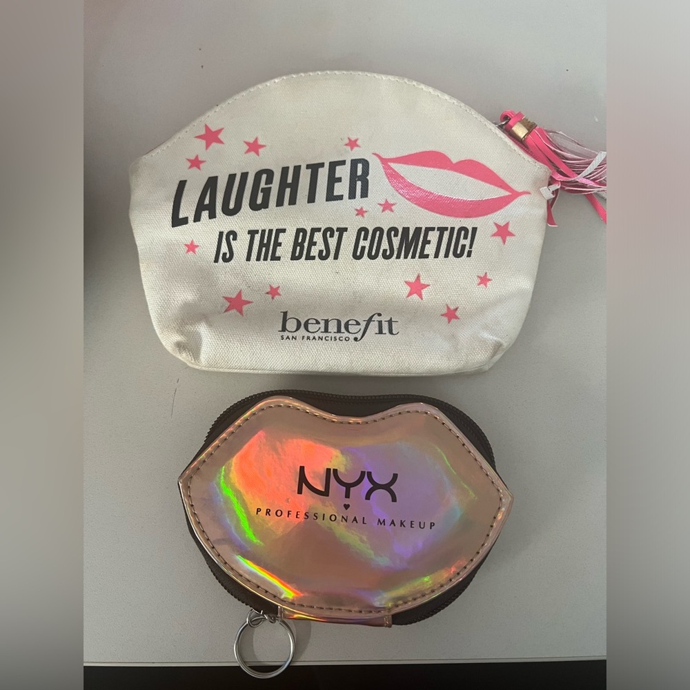 Two makeup bags. One small- shape of lips, other bigger benefit bag with tassel